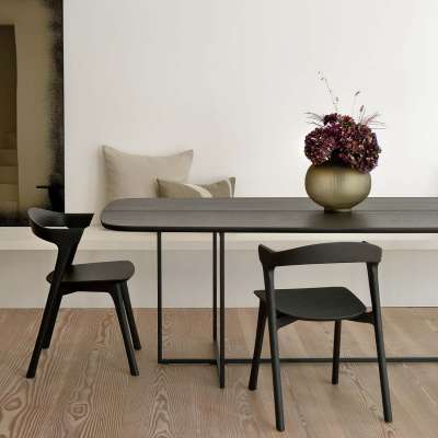 Italian Style – Wohnen mit Riviera-Chic 5 Dunkler Eichenholztisch vor weißer Wand. Typisch Italian Style.