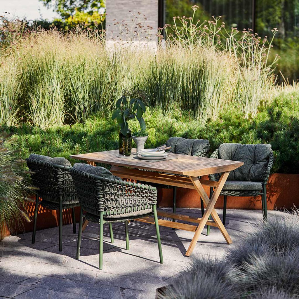 Gartenmöbel Materialien: 6 heiße Anwärter für die Outdoor-Saison 9 Der salbengrüne Cane-line Ocean Stuhl im Vierer-Ensemble mit Holztisch.
