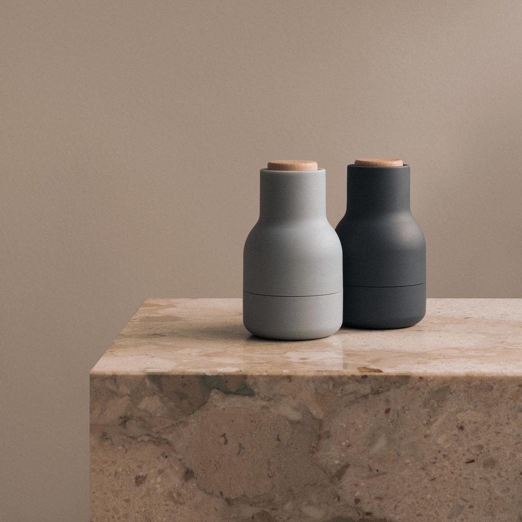 Hygge – so wird Wohnen zum Wohlfühlen 8 Zwei Audo Bottle Grinder Mini Gewürzmühlen in Hellgrau und Schwarz auf einer Marmor-Küchenplatte.
